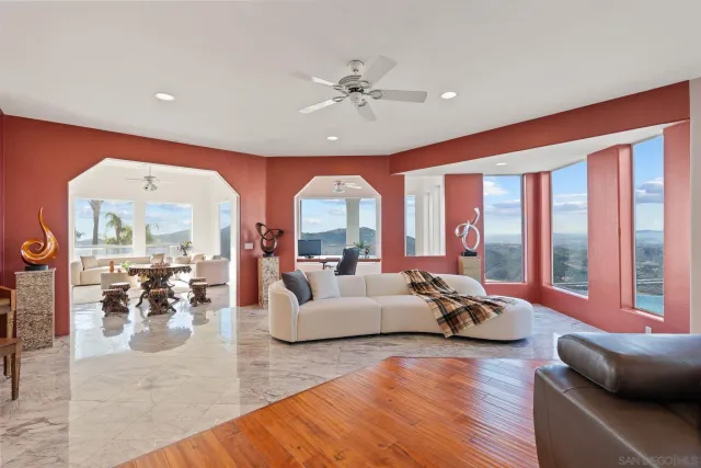 a living room with furniture kitchen view and large windows