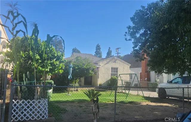 a front view of a house with a yard and trees