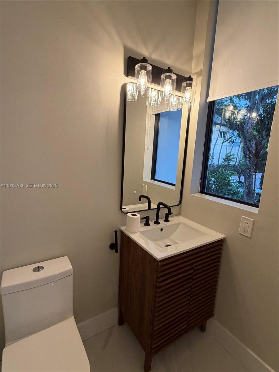 570 Fernwood Road Key Biscayne, FL 33149 - Photo 9 of 18 a bathroom with a toilet sink and mirror