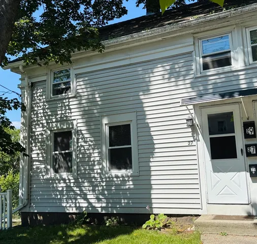 a view of a house with a door and a tree