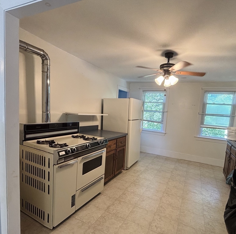 27 Fletcher Street, Unit 1 Northbridge, MA 01588 - Photo 6 of 12 a kitchen with stainless steel appliances granite countertop a stove and a refrigerator