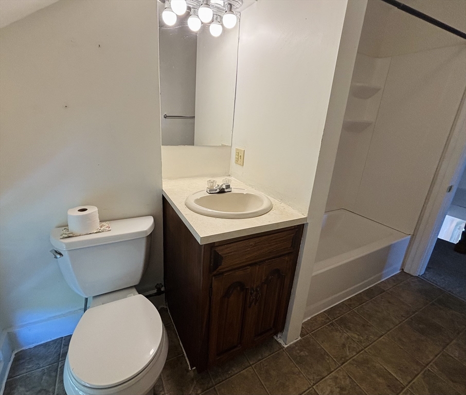 27 Fletcher Street, Unit 1 Northbridge, MA 01588 - Photo 8 of 12 a bathroom with a toilet a sink and mirror