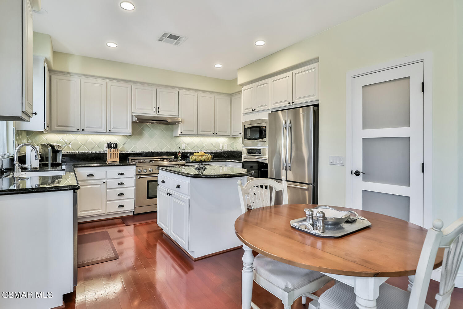 4904 Promenade Street Simi Valley, CA 93063 - Photo 21 of 63 a kitchen with stainless steel appliances granite countertop a sink a stove a refrigerator and white cabinets