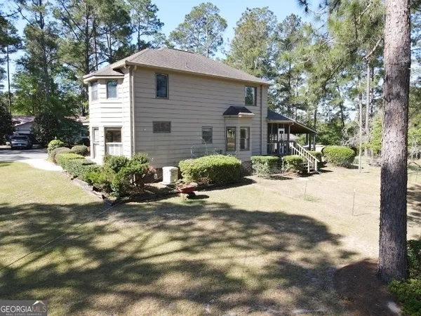 a view of a house with yard and sitting area