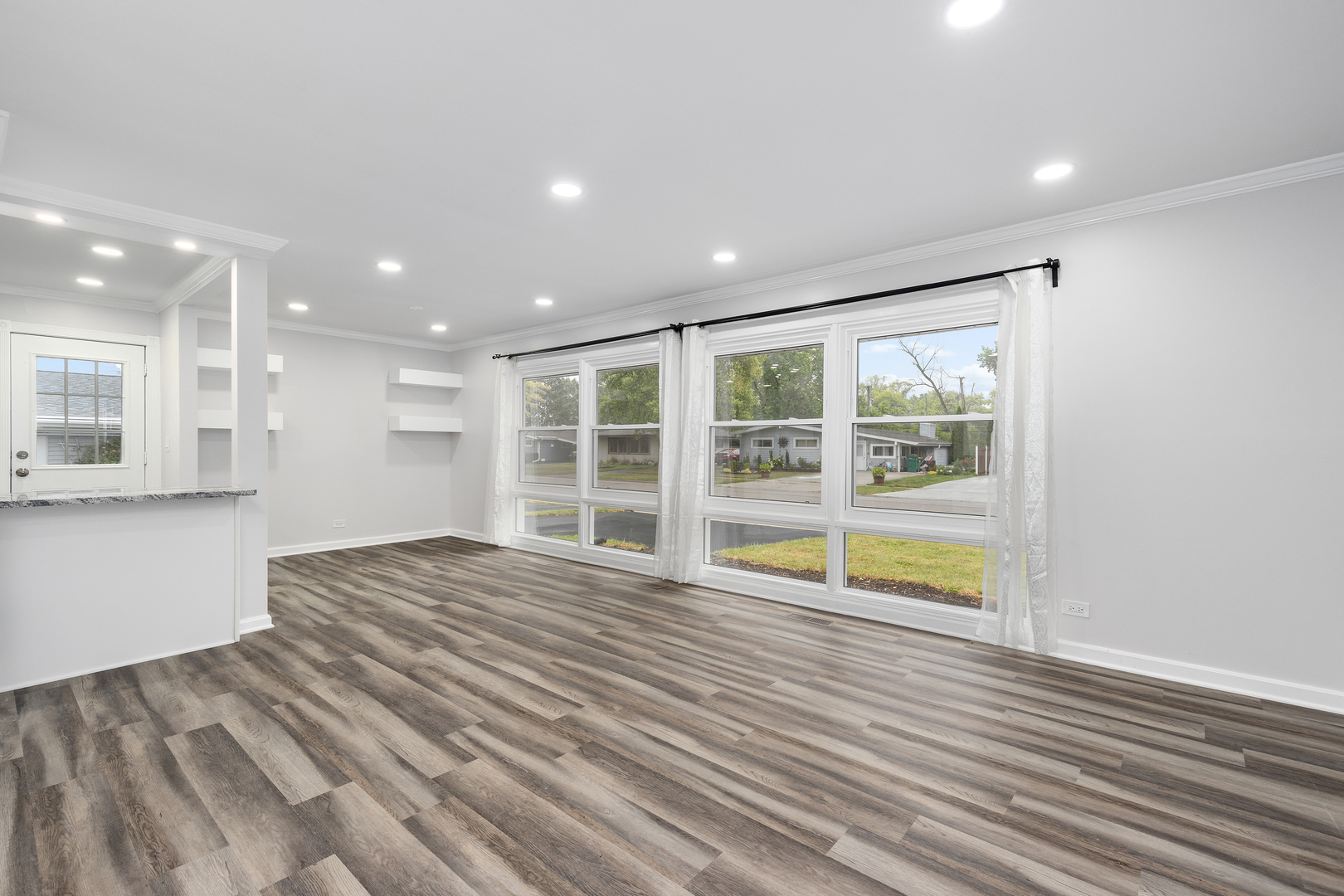 388 Nancy Lane Wheeling, IL 60090 - Photo 4 of 22 a view of an empty room with wooden floor and a window