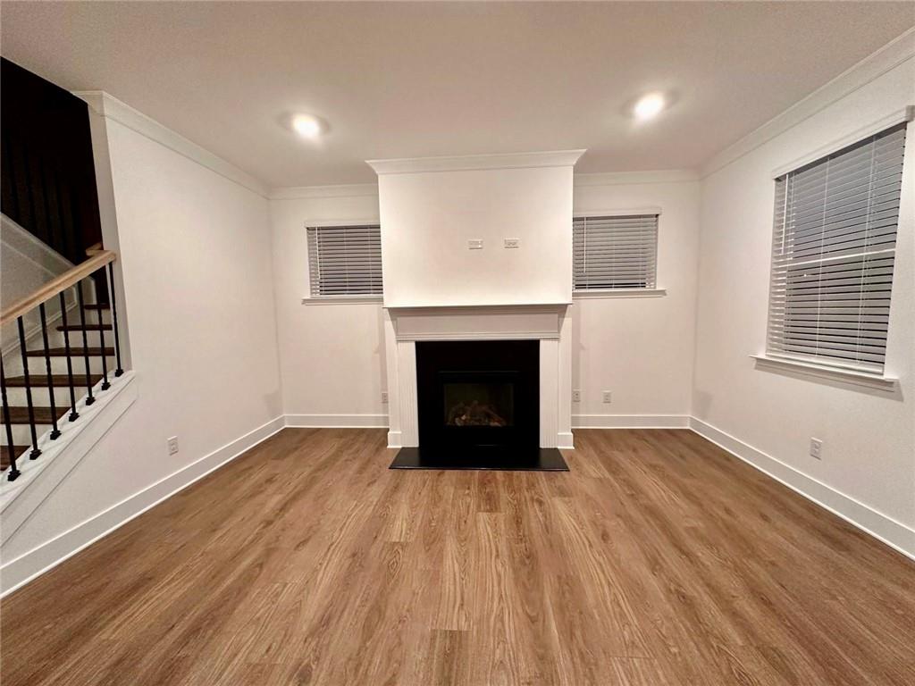 537 Hyde Rdg Trail Loganville, GA 30052 - Photo 4 of 23 an empty room with wooden floor and fireplace