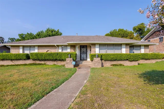 a front view of a house with a yard and plants