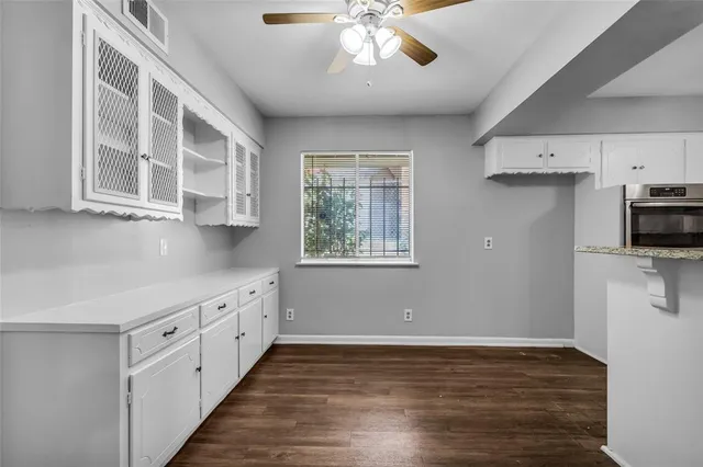 a kitchen with granite countertop white cabinets and white appliances