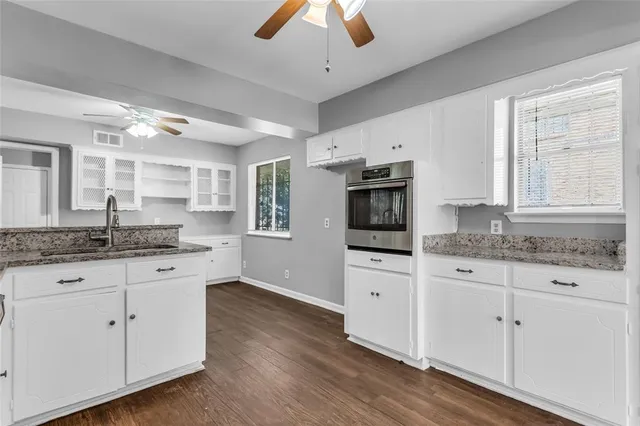 a kitchen with granite countertop white cabinets and white appliances
