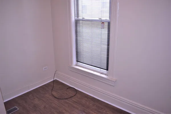 a view of a room with wooden floor and a window