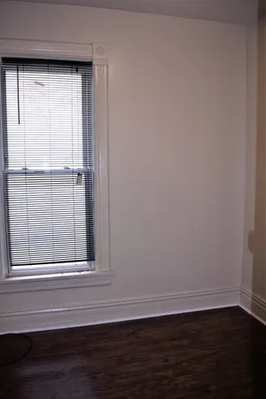 a view of a small space with wooden floor and a window