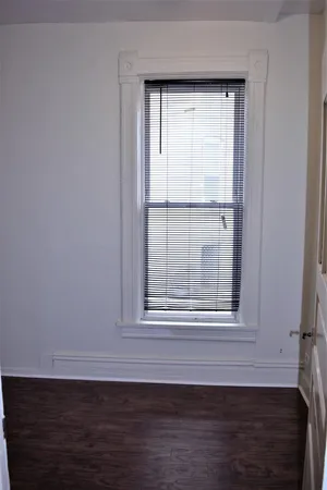 a view of empty room with wooden floor and cabinet