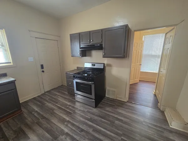 a kitchen with wooden floors and appliances