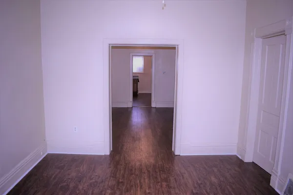 a view of a room with wooden floor and a window