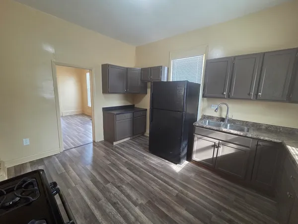 a kitchen with a refrigerator stove and wooden cabinets