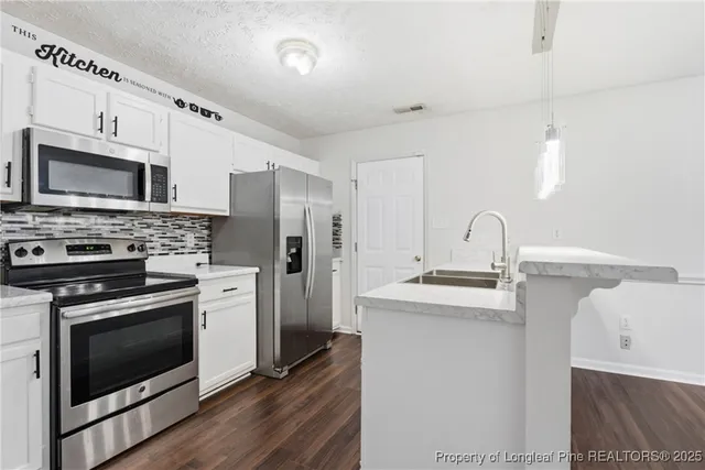 a kitchen with stainless steel appliances a stove sink and refrigerator