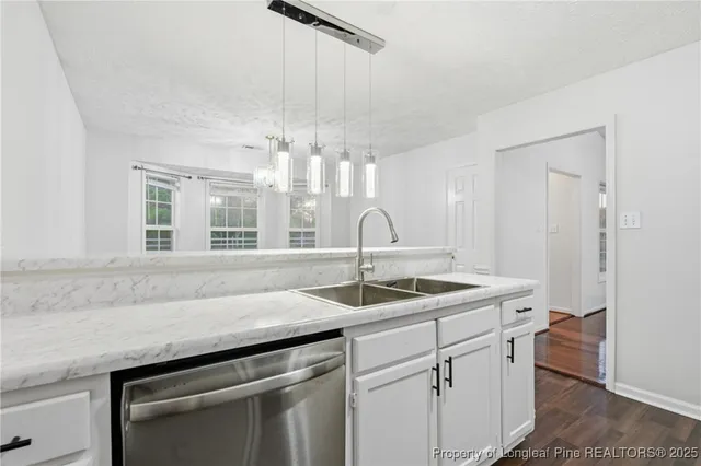 a kitchen with a sink and chandelier