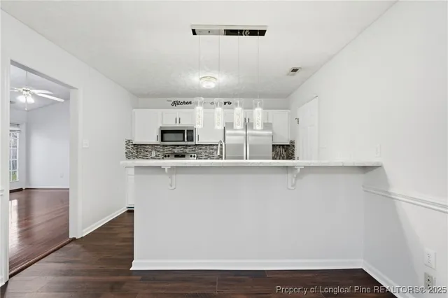 a kitchen with stainless steel appliances a refrigerator sink and microwave