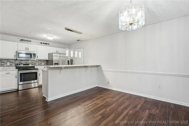 a kitchen with granite countertop a stove a microwave and wooden floor