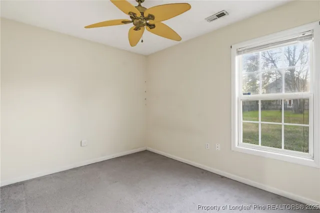 an empty room with fan and windows