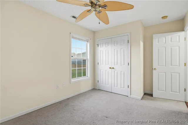 a view of a room with a chandelier fan