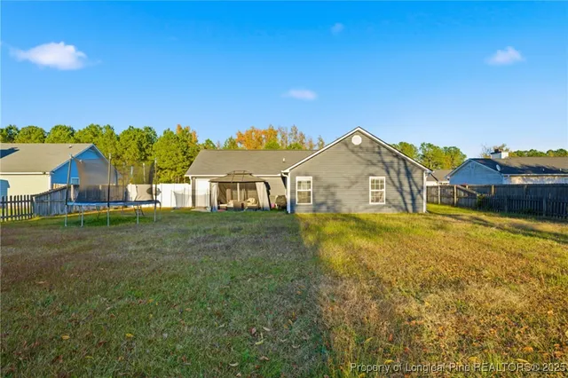 a view of an house with backyard and swimming pool