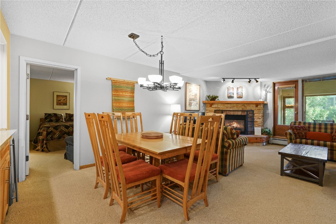 800 Copper Road, Unit 206 Copper Mountain, CO 80443 - Photo 3 of 22 a dining room with furniture a fireplace and a chandelier