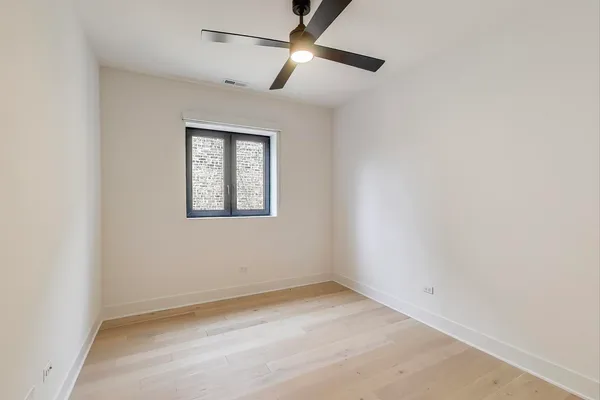 an empty room with a window and a fan