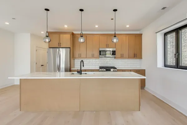 a kitchen with stainless steel appliances granite countertop a sink a stove and a refrigerator