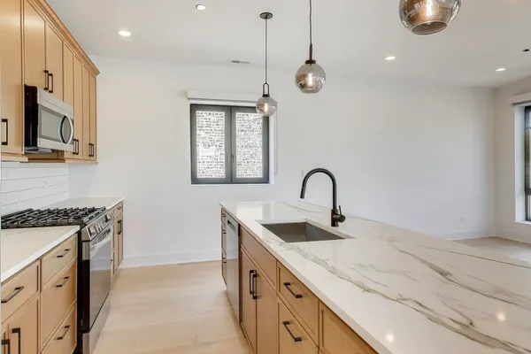 a kitchen with stainless steel appliances granite countertop a sink a stove and a wooden floors