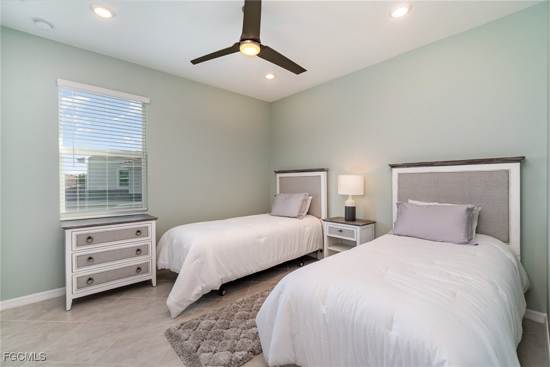 3771 Pebblebrook Ridge Court, Unit 201 Fort Myers, FL 33905 - Photo 14 of 45 a bedroom with two beds and a chandelier