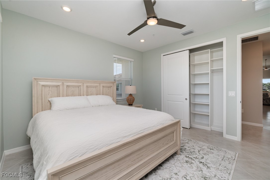 3771 Pebblebrook Ridge Court, Unit 201 Fort Myers, FL 33905 - Photo 17 of 45 a bedroom with a bed and a ceiling fan