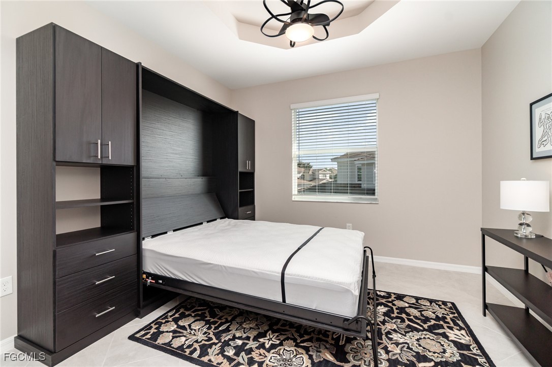 3771 Pebblebrook Ridge Court, Unit 201 Fort Myers, FL 33905 - Photo 20 of 45 a bedroom with a bed and a chandelier