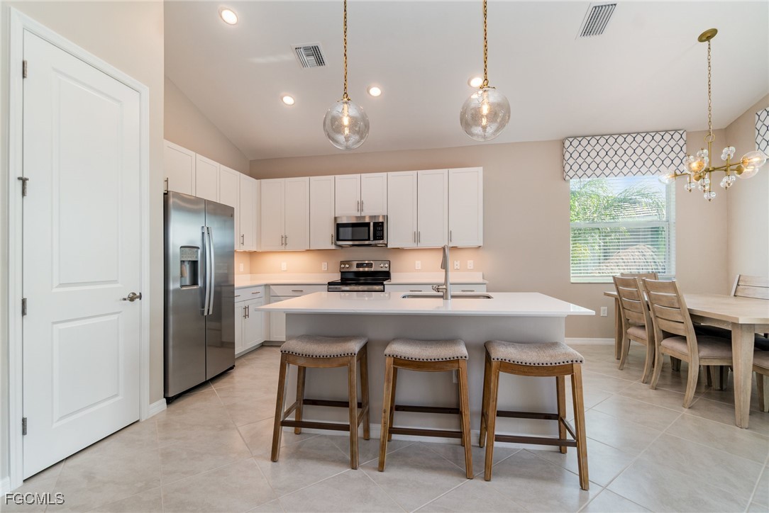 3771 Pebblebrook Ridge Court, Unit 201 Fort Myers, FL 33905 - Photo 8 of 45 a kitchen with kitchen island a dining table chairs and a refrigerator