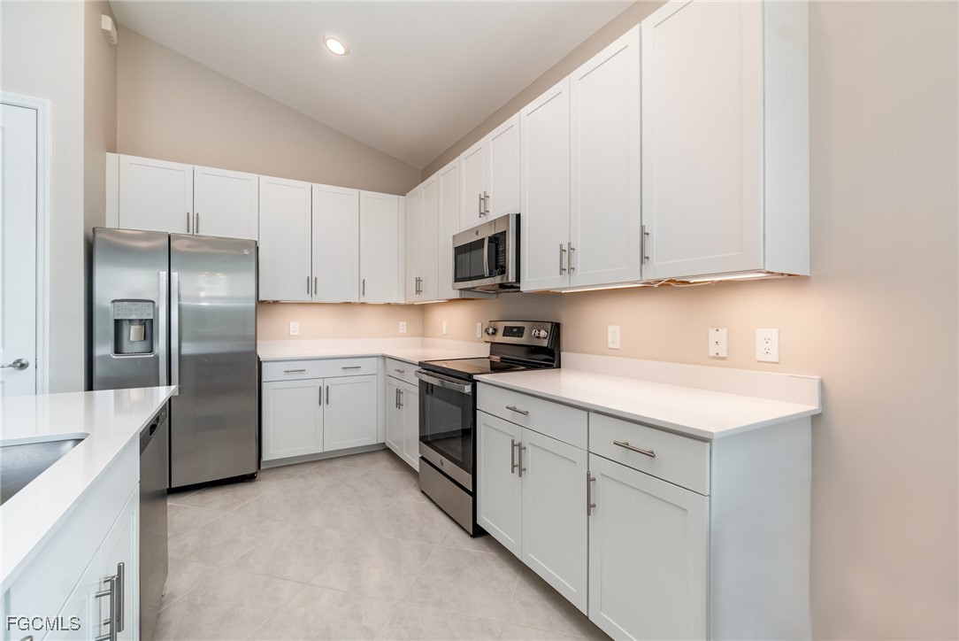 3771 Pebblebrook Ridge Court, Unit 201 Fort Myers, FL 33905 - Photo 10 of 45 a kitchen with white cabinets and stainless steel appliances