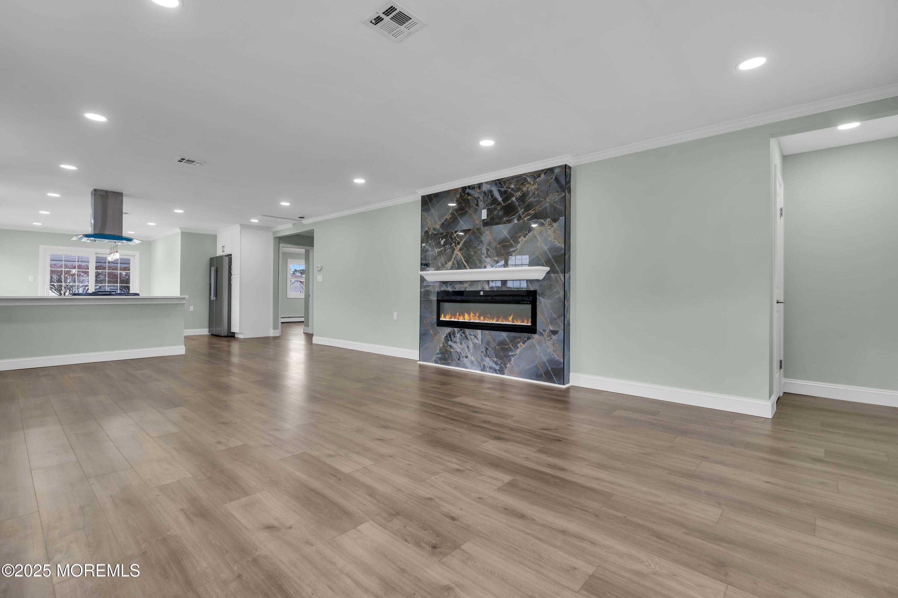 10 Aztec Court Toms River, NJ 08757 - Photo 19 of 57 a view of an empty room with wooden floor kitchen view and a window
