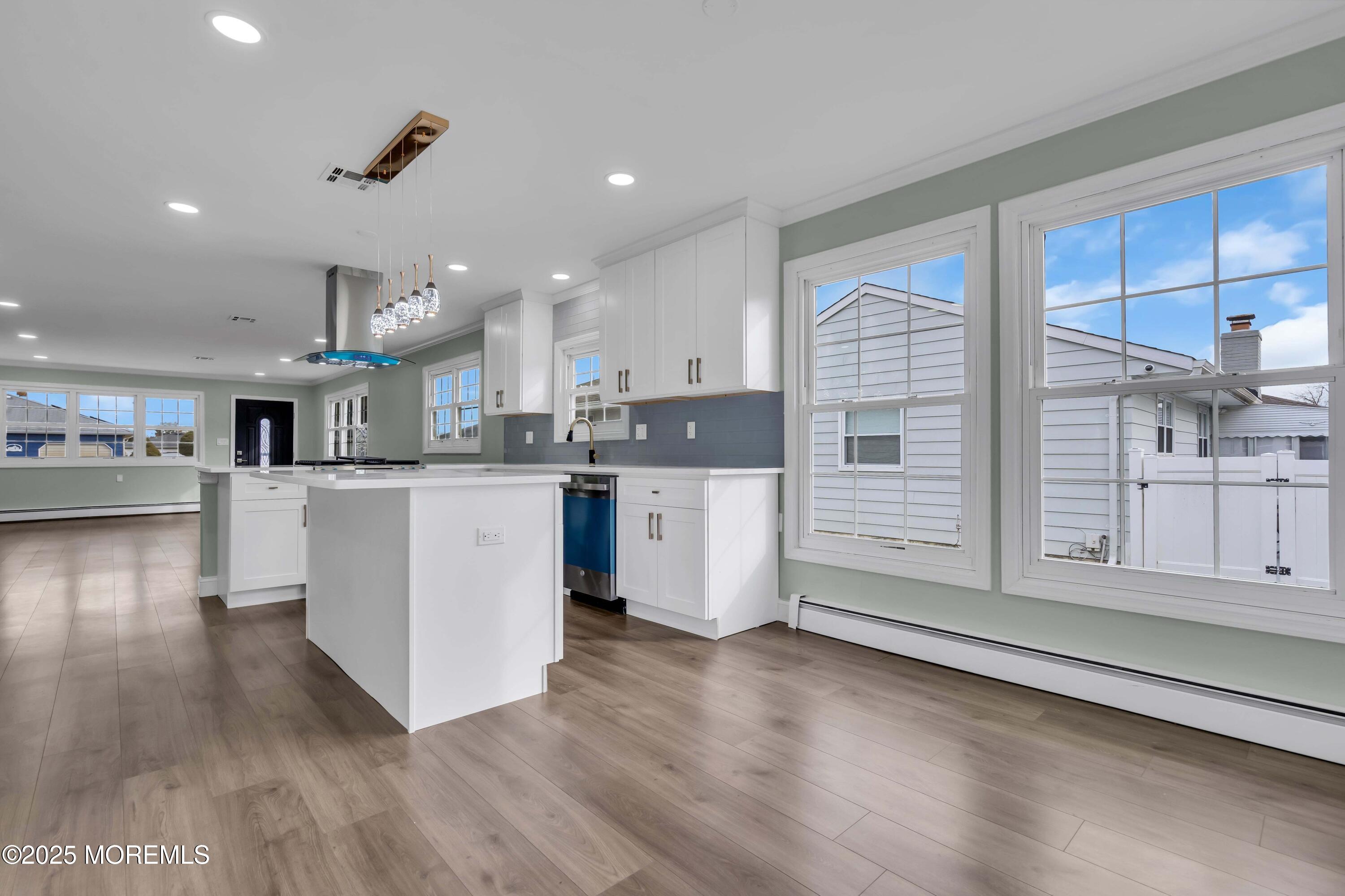 10 Aztec Court Toms River, NJ 08757 - Photo 40 of 57 a kitchen with stainless steel appliances kitchen island granite countertop a stove a sink and white cabinets with wooden floor