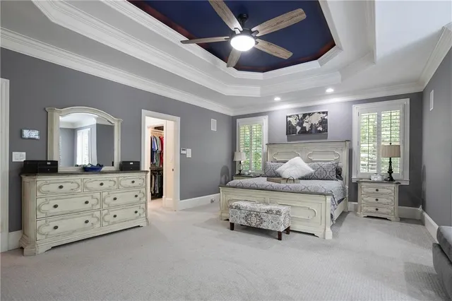 a bedroom with a bed and a flat tv screen on the dresser