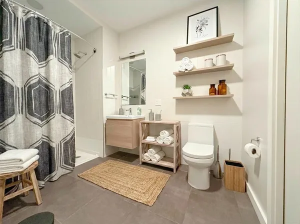 a bathroom with a sink a toilet and a shower curtain