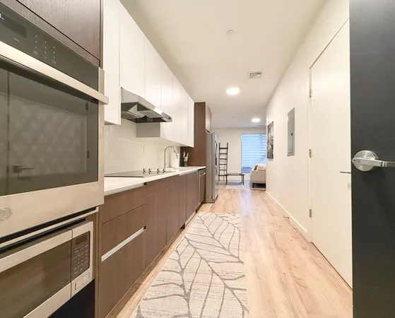 a large white kitchen with kitchen island white cabinets and stainless steel appliances