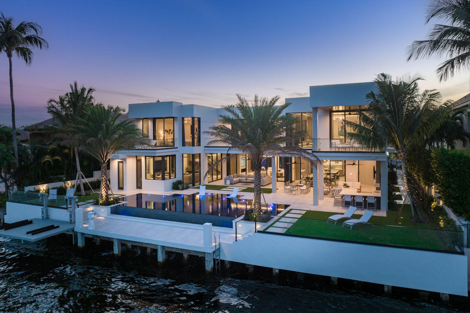 500 East Alexander Palm Road Boca Raton, FL 33432 - Photo 89 of 89 a front view of a house with a yard fountain and a table and chairs