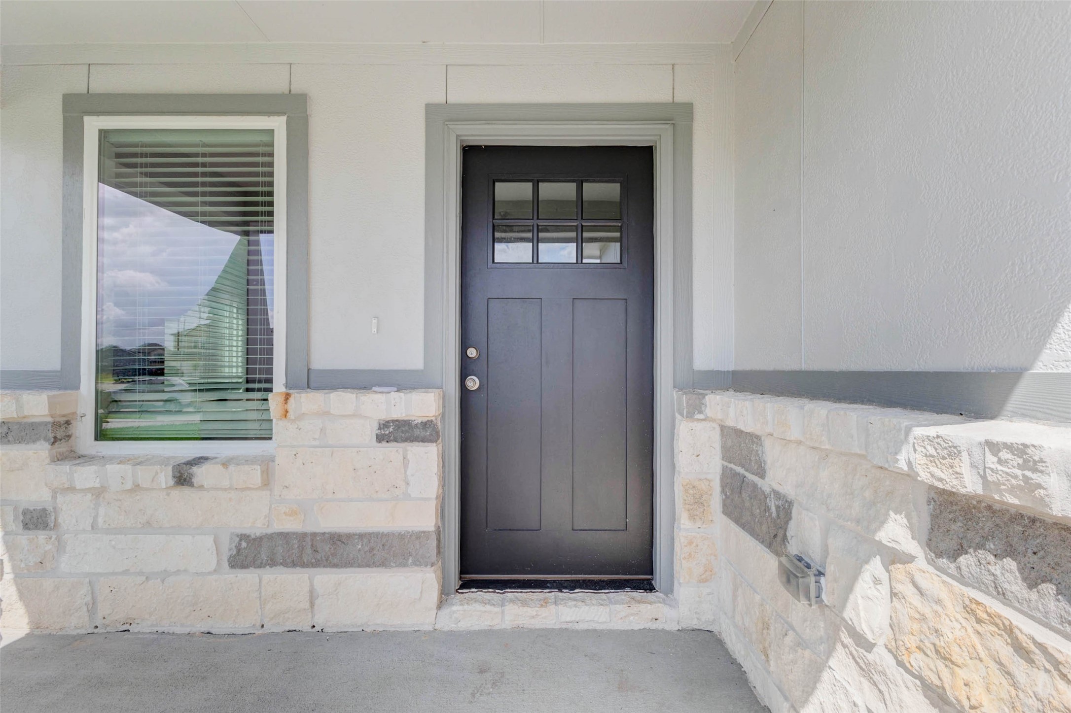 6463 Escondido Drive Rosharon, TX 77583 - Photo 7 of 30 Covered front porch with stone accents, a black front door, and a front window that brings in natural light. This inviting entry gives the home a polished first impression while offering a protected space to welcome guests.