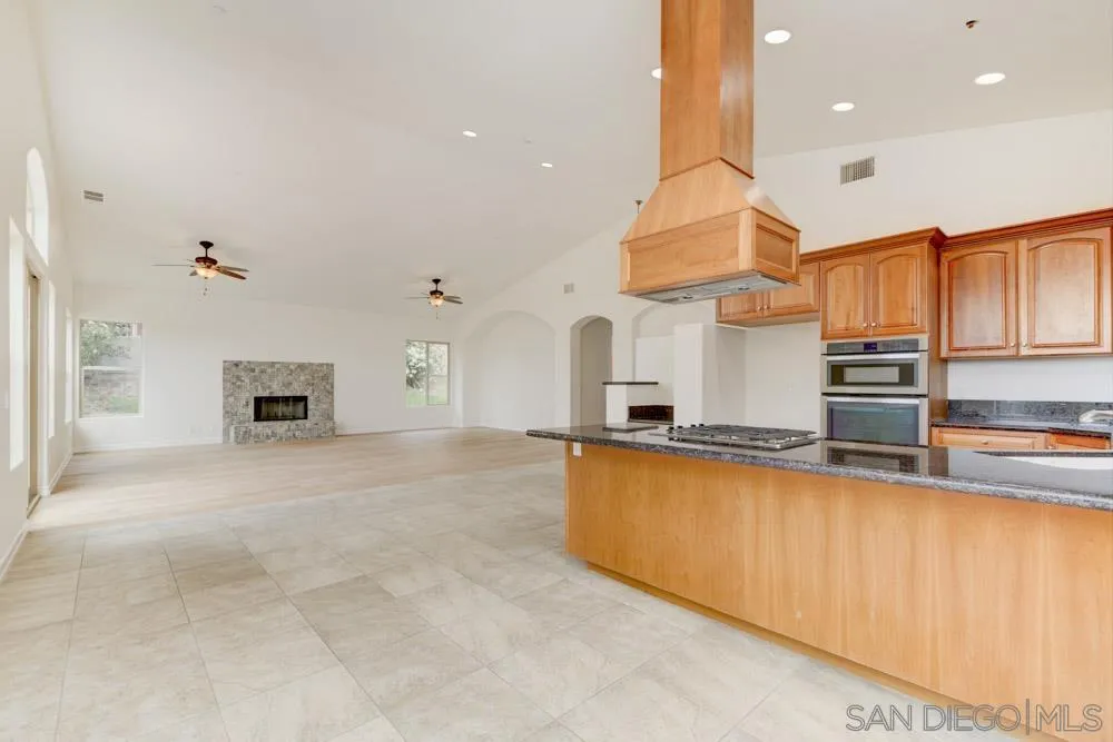 3650 Emma Road Vista, CA 92084 - Photo 12 of 25 a large kitchen with stainless steel appliances a large counter top a stove and a refrigerator