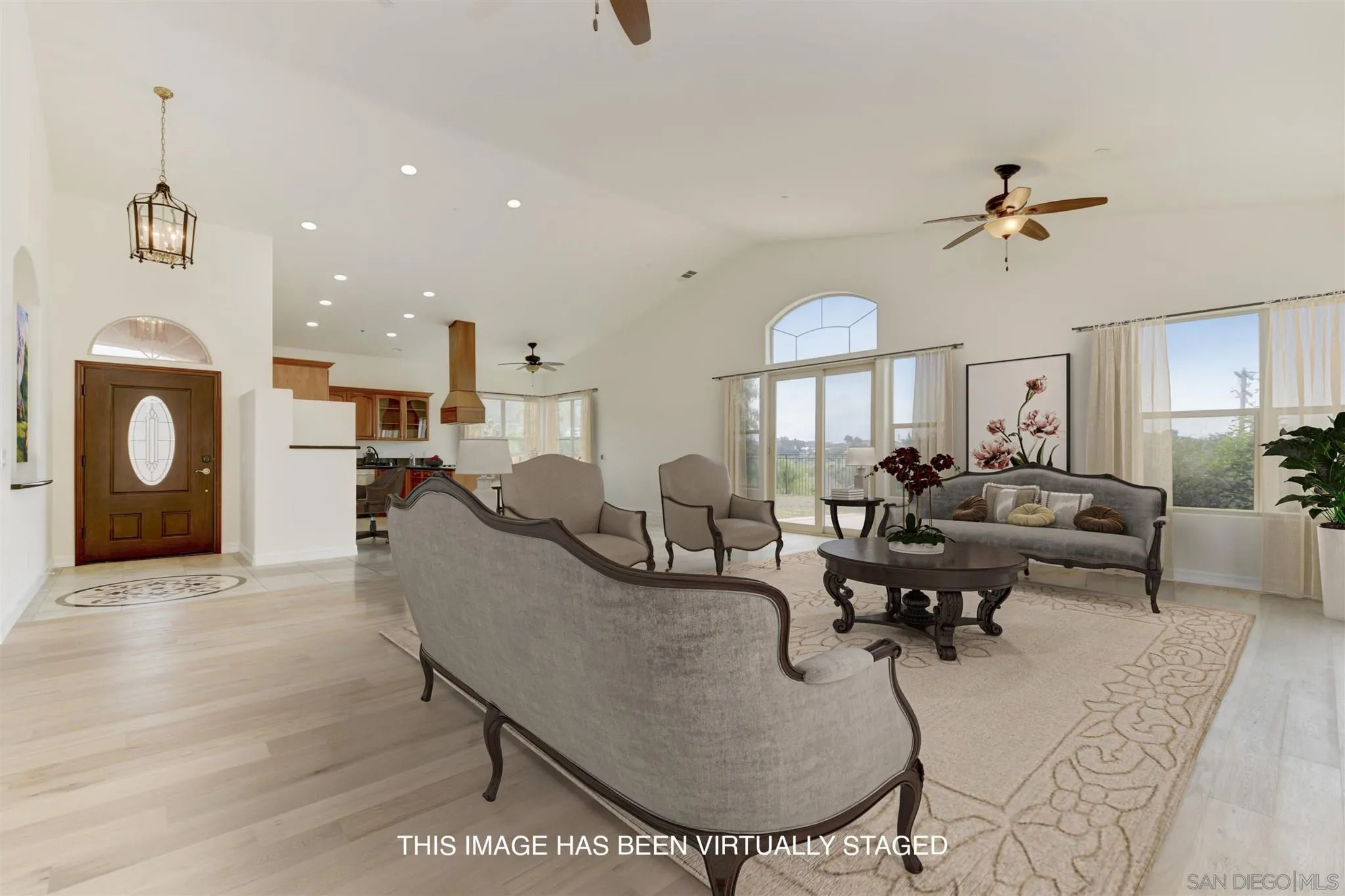 3650 Emma Road Vista, CA 92084 - Photo 3 of 25 a living room with furniture a fireplace and a chandelier