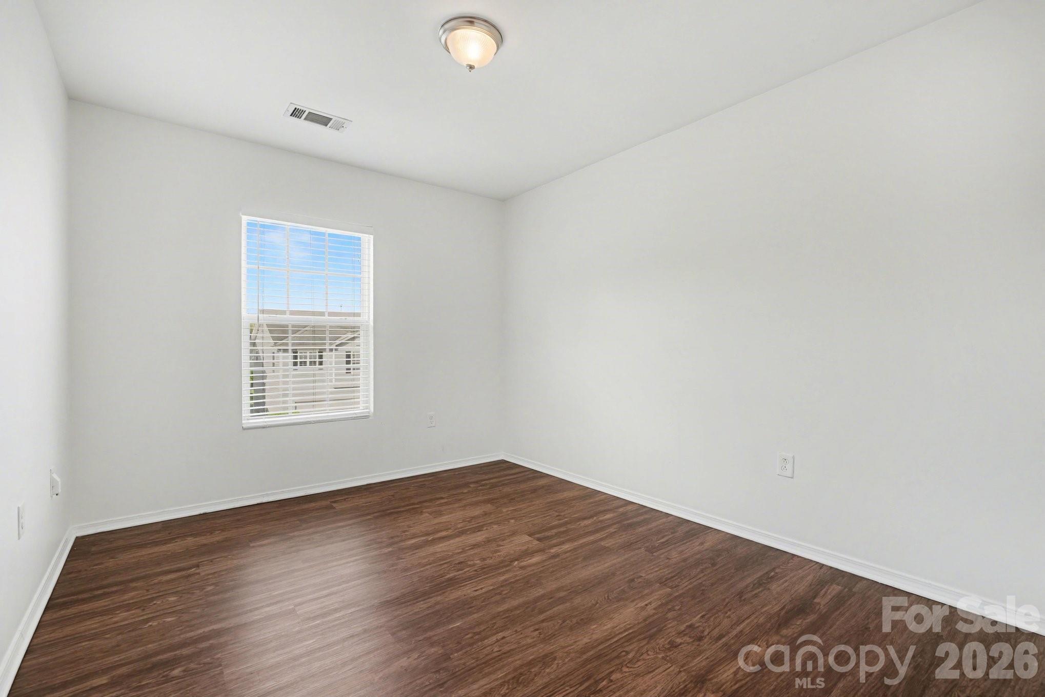 4400 Kiddle Lane Monroe, NC 28110 - Photo 22 of 28 an empty room with wooden floor and windows