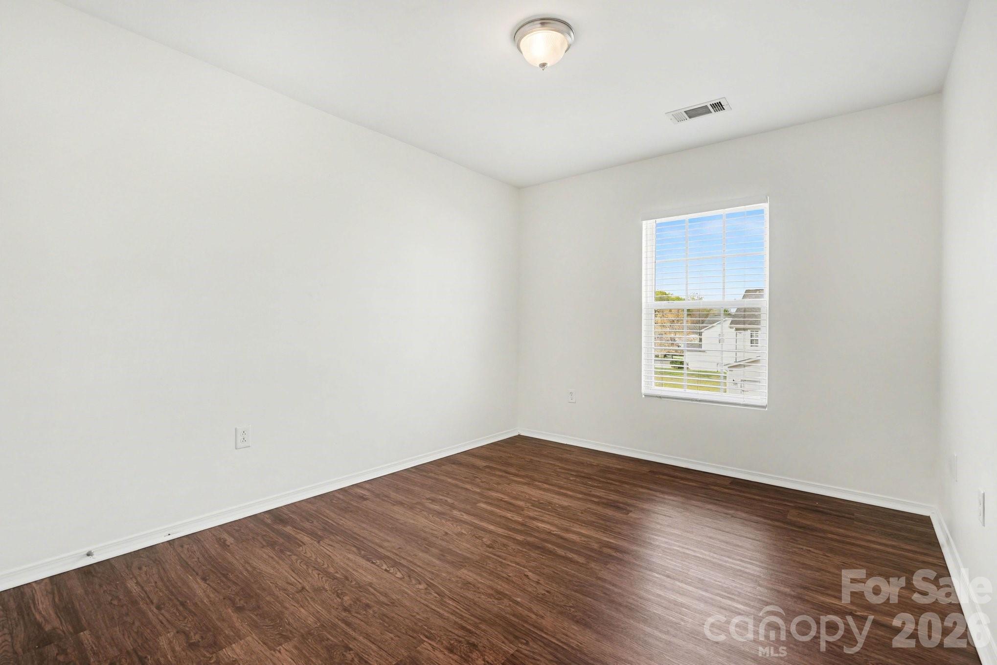 4400 Kiddle Lane Monroe, NC 28110 - Photo 23 of 28 an empty room with wooden floor and windows