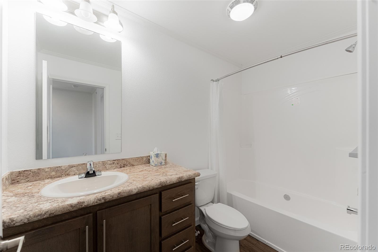 9 Timberlake Road Byers, CO 80103 - Photo 13 of 28 a bathroom with a granite countertop sink a toilet and a mirror