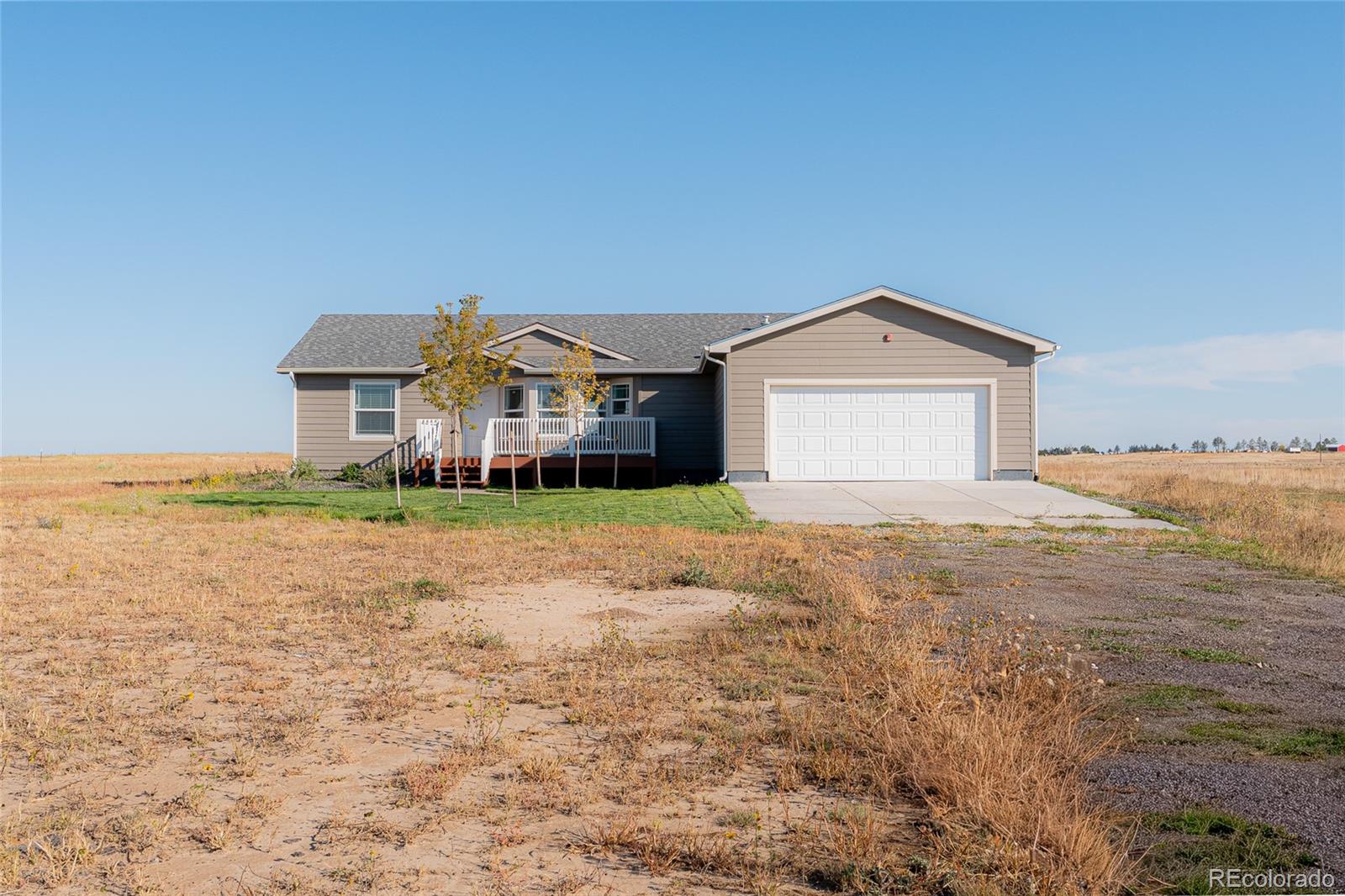 9 Timberlake Road Byers, CO 80103 - Photo 2 of 28 a front view of a house with a yard and garage