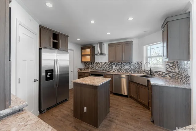 a kitchen with stainless steel appliances granite countertop a refrigerator a stove a sink and a microwave