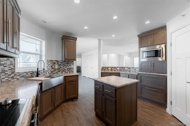 a kitchen with stainless steel appliances granite countertop a sink stove and cabinets
